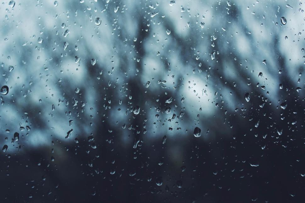 Free Image of Raindrops on a window with a blurry background view. 