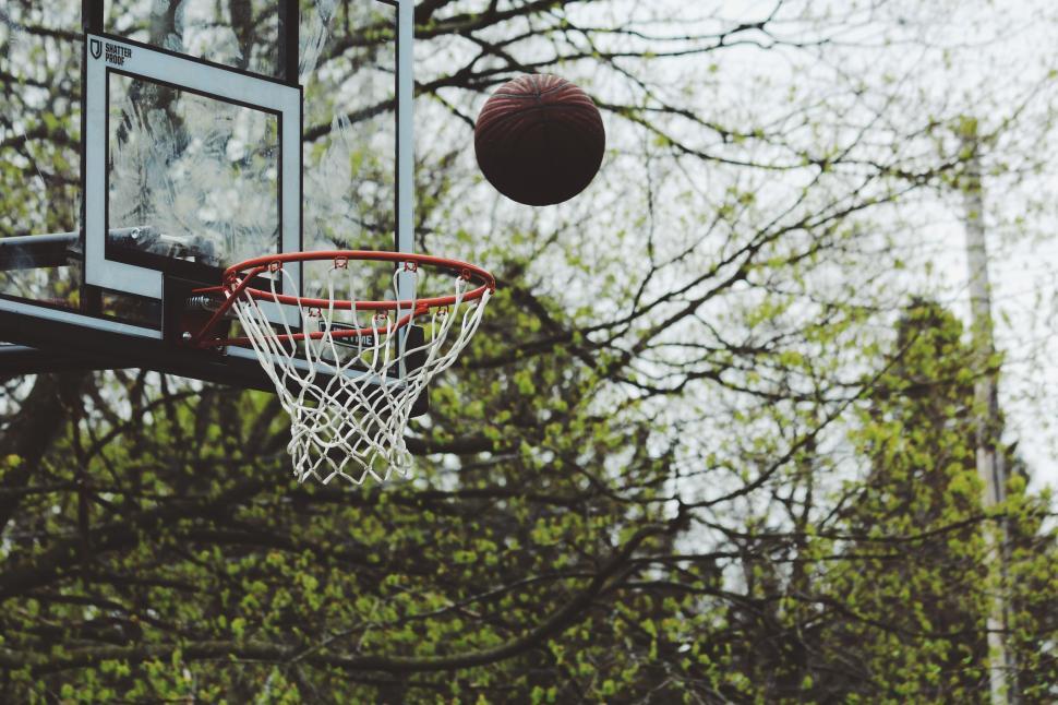 Free Image of Basketball heading towards the hoop outdoors in daytime. 