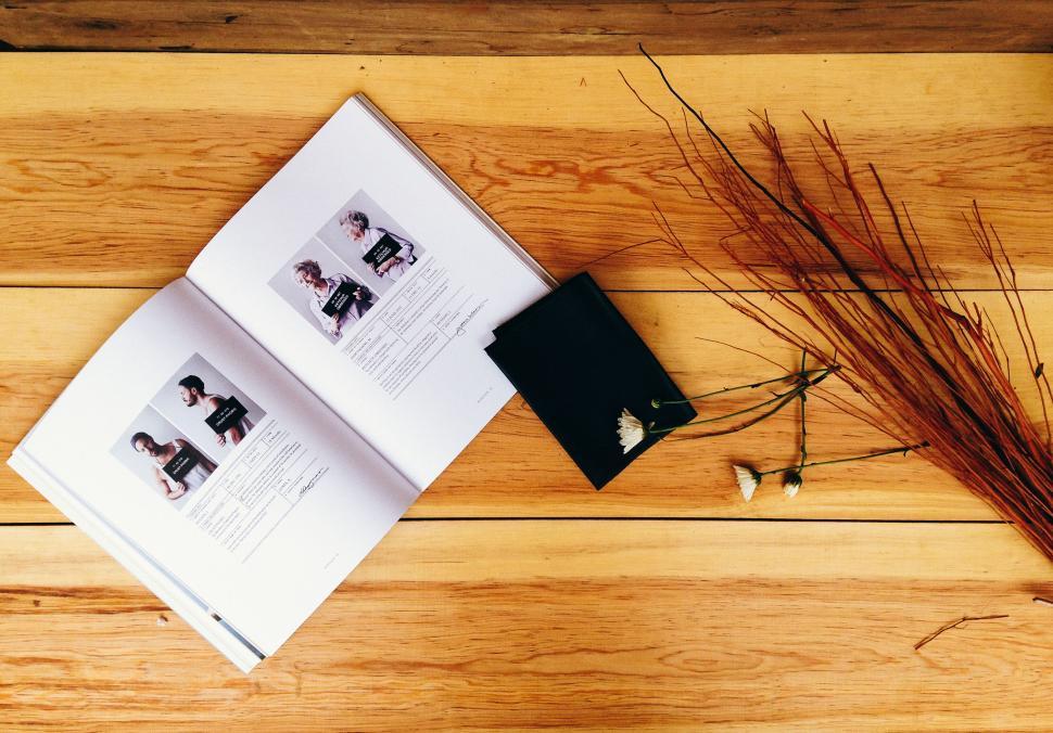 Free Image of Open book and stationery on a wooden table surface. 