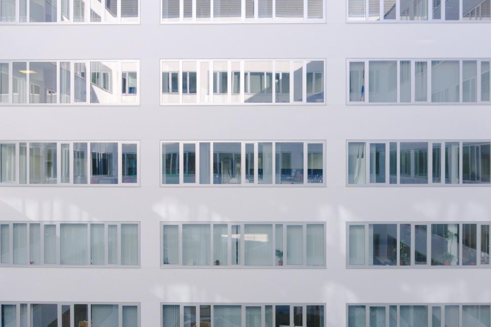Free Image of Modern white building with symmetrical windows in sunlight 