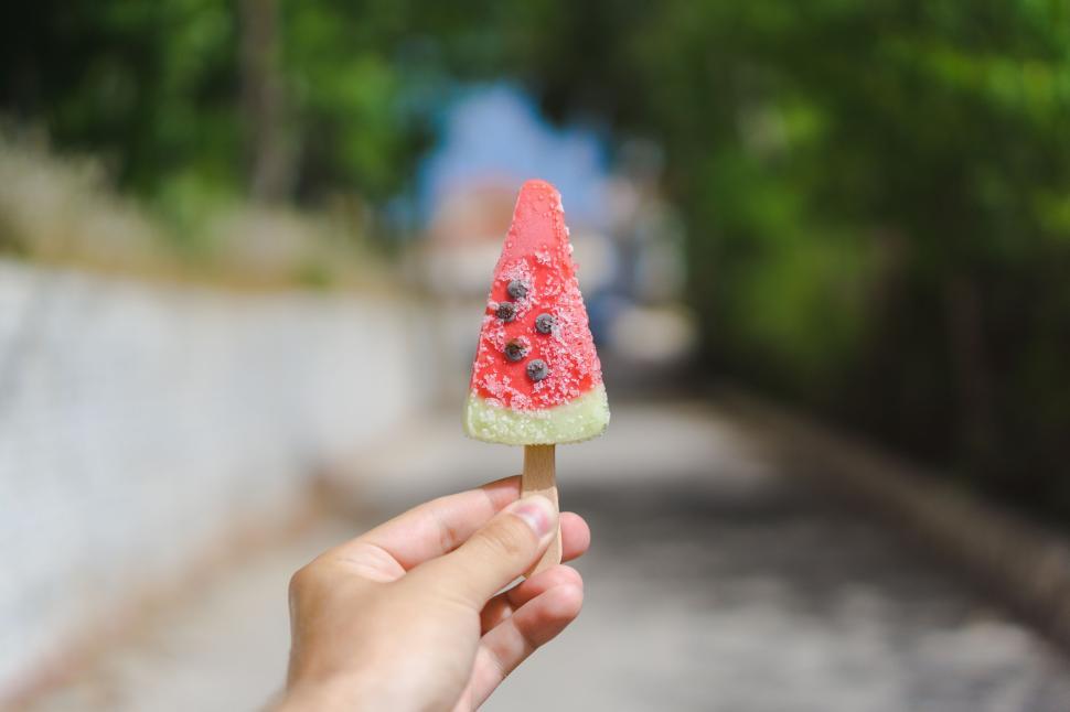Free Image of Hand holding watermelon ice cream on a sunny day. 