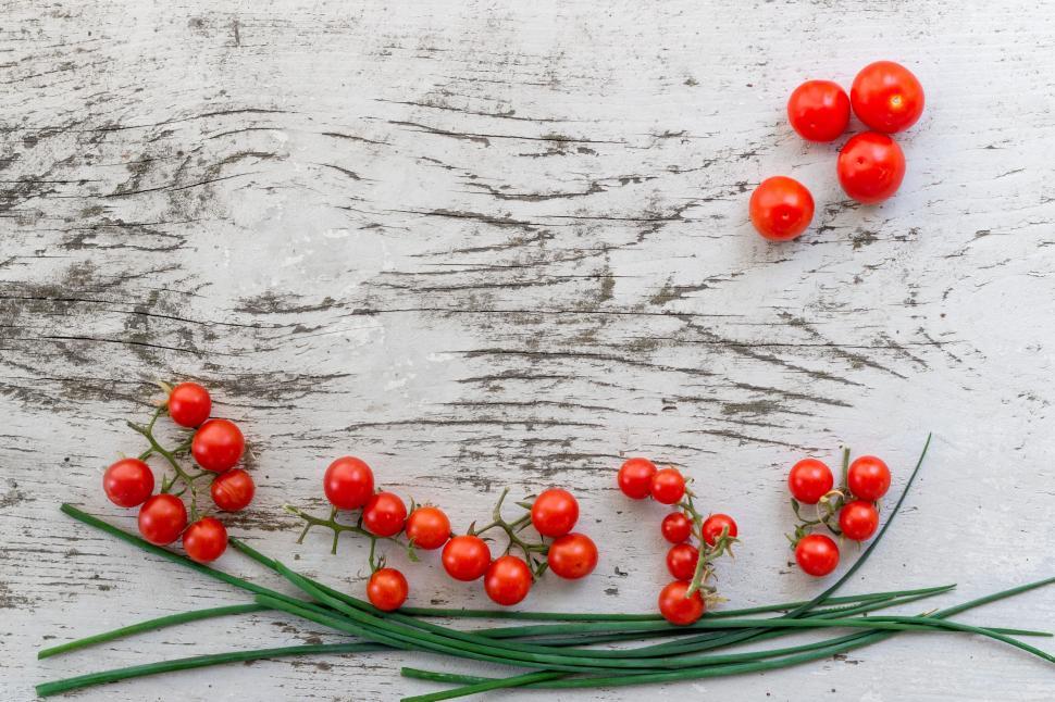 Free Image of Cherry tomatoes and chives neatly arranged on wood 