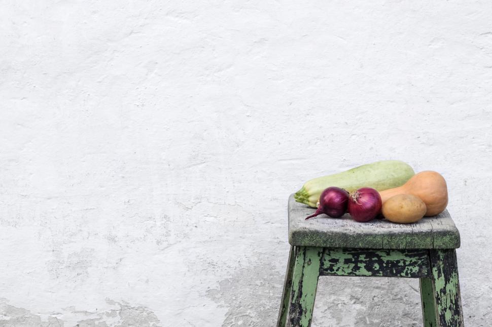 Free Image of Assorted vegetables on worn green stool against wall 