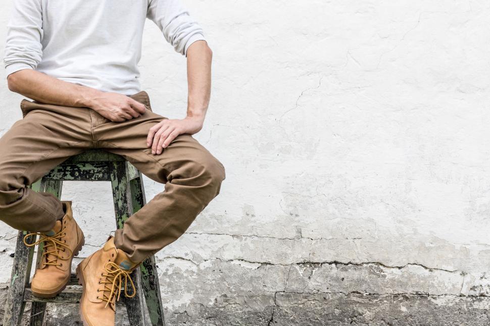 Free Image of Man in brown pants and boots sitting on a stool. 