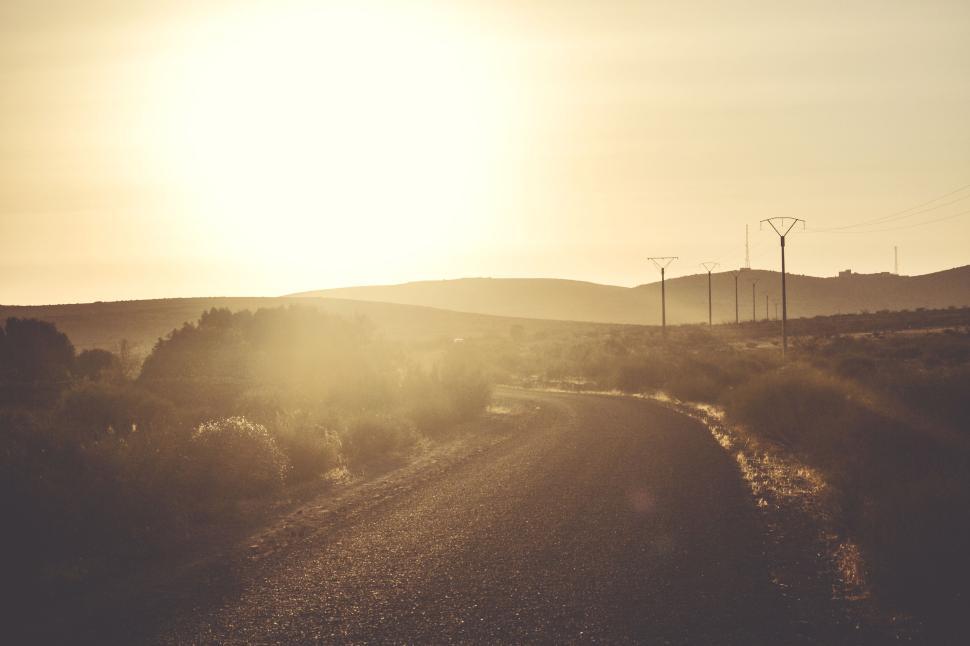 Free Image of Sunset over a tranquil winding road in the countryside. 