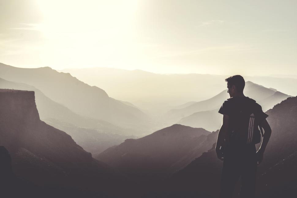 Free Image of Person overlooking mountains and valley at sunrise. 