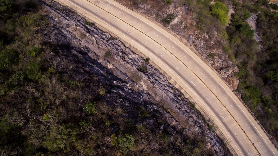Free Image of Winding road captured from above beside rocky terrain 