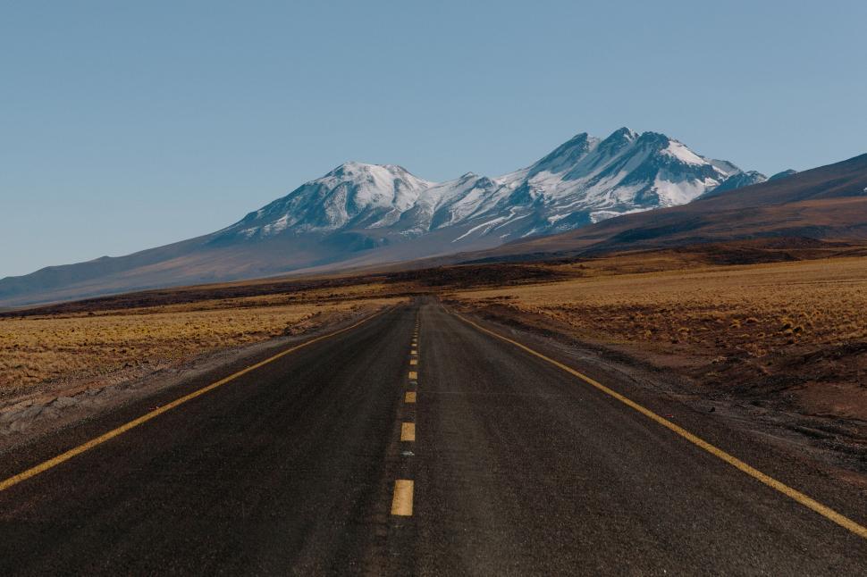 Free Image of Straight road leading towards distant snowy mountains 