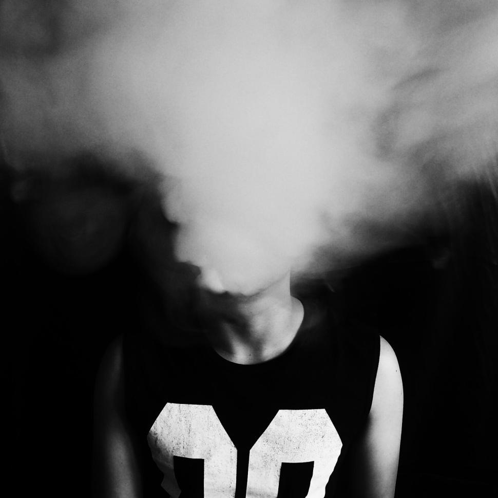 Free Image of Person with face obscured by cloud of thick smoke. 