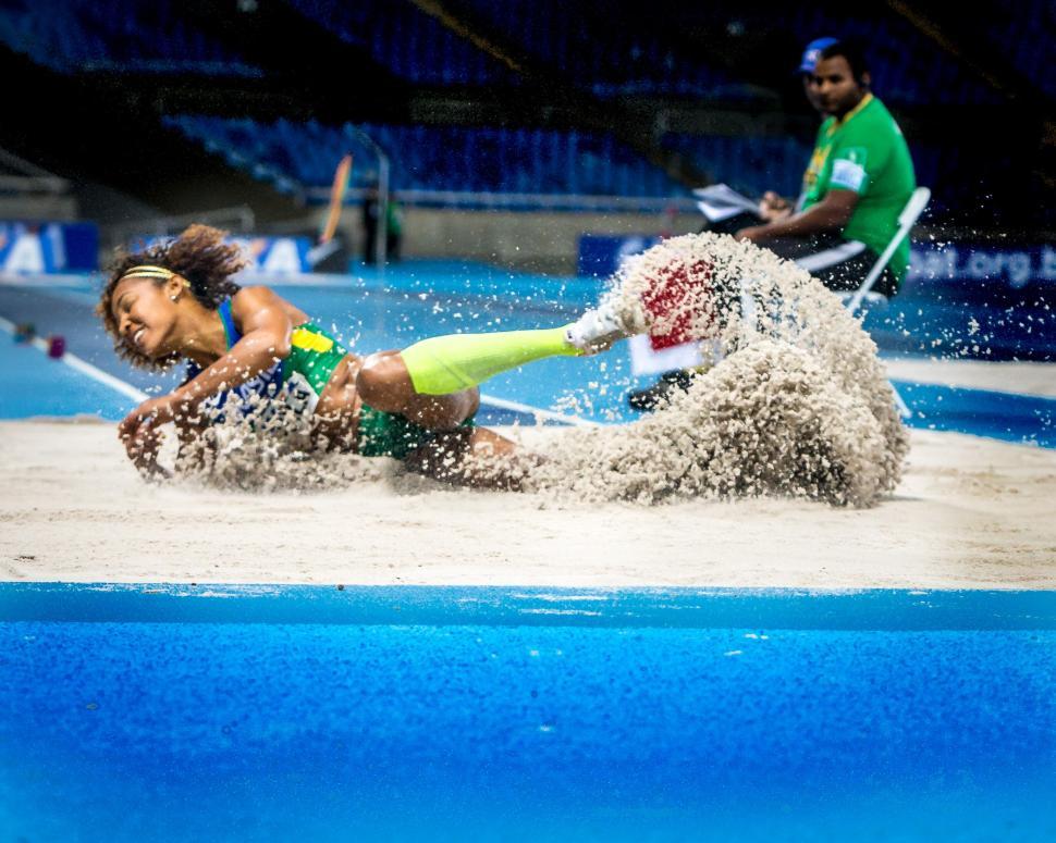 Free Image of Athlete landing in long jump sand with forceful impact 