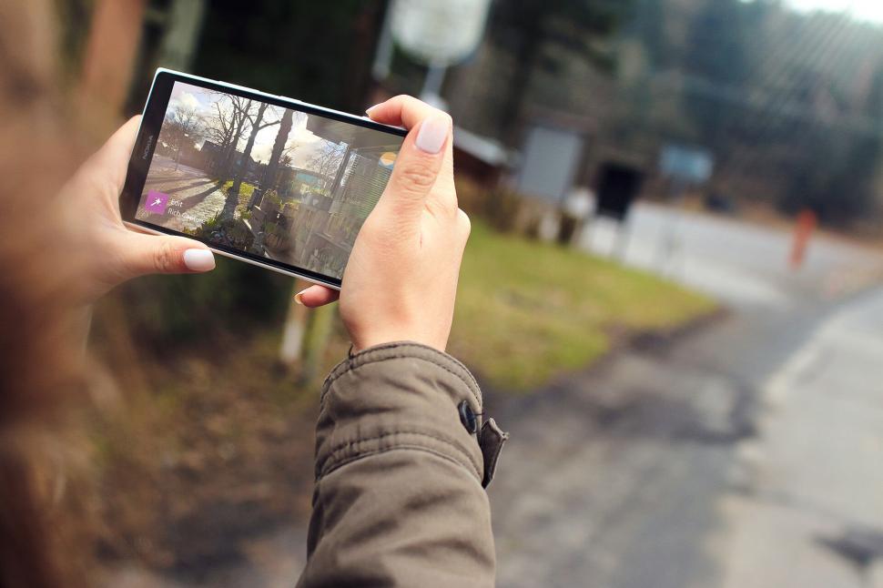 Free Image of Person taking a photo with smartphone in outdoor setting. 