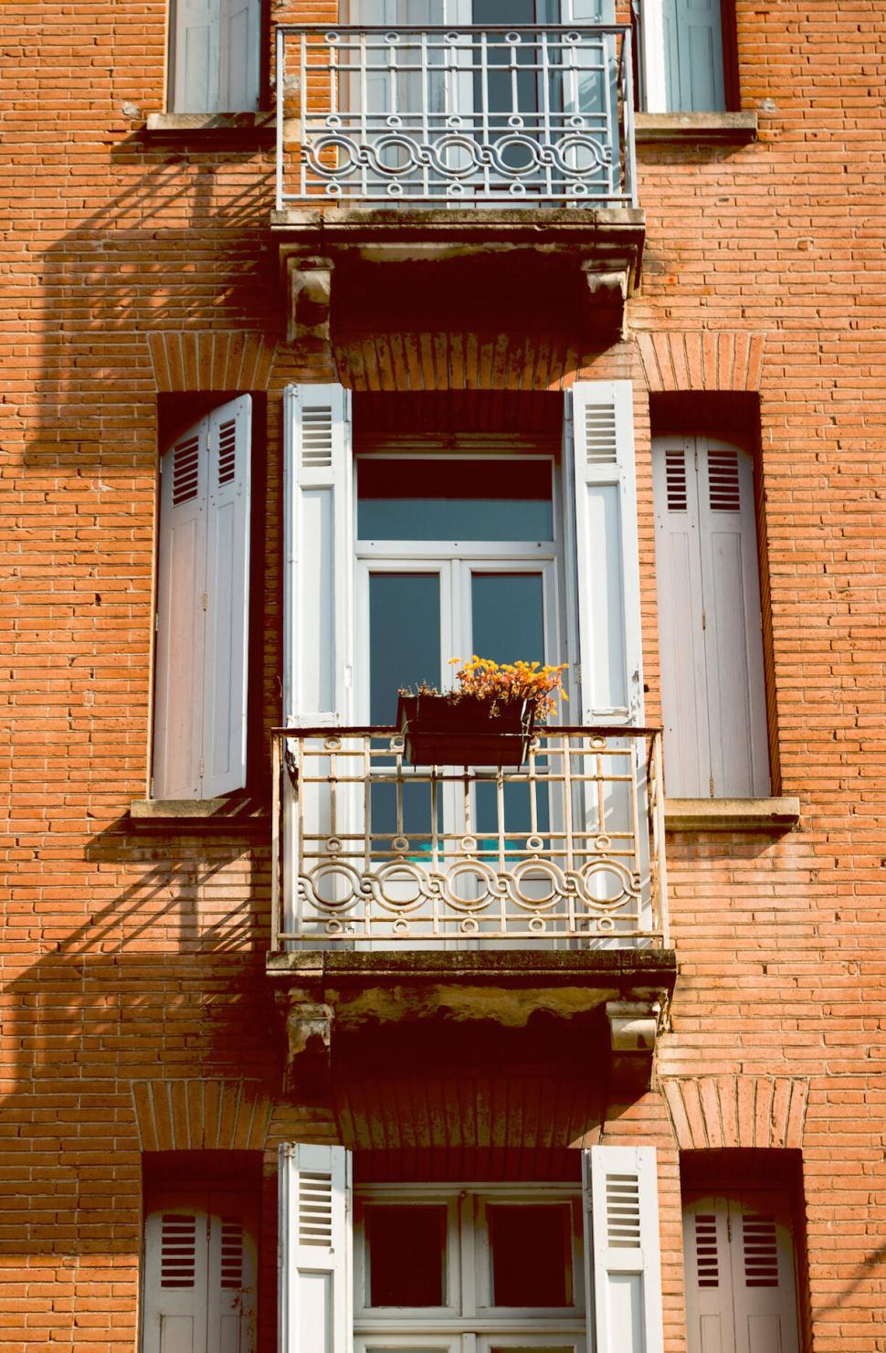Free Image of Classic brick building facade with multiple balconies. 