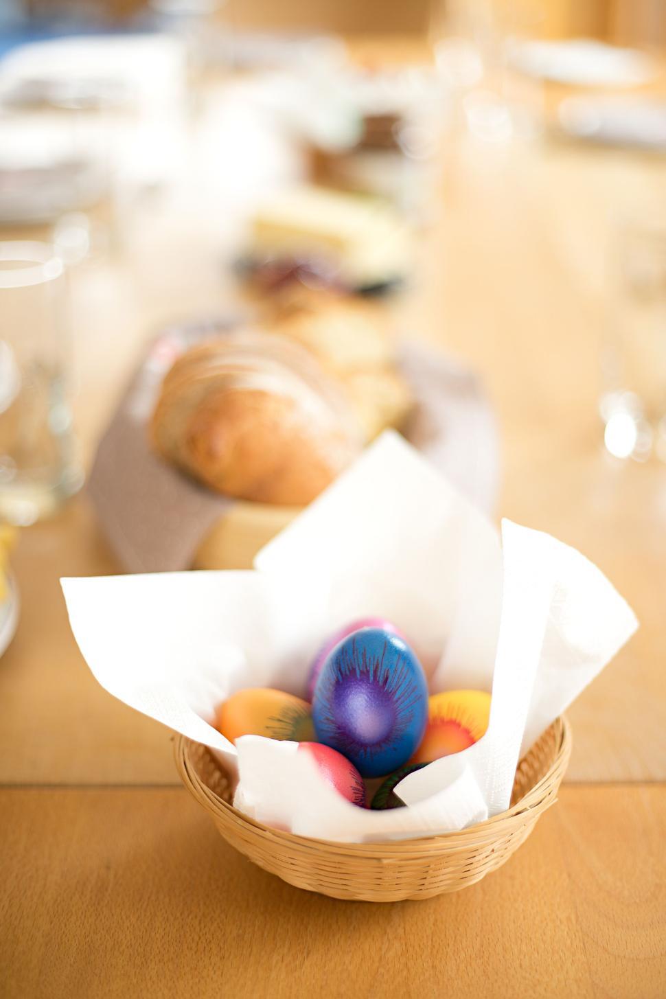 Free Image of Vibrant Easter eggs in a basket with a blurred background. 