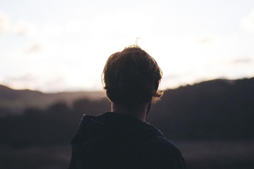 Free Image of Person from behind looking at sunrise or sunset horizon 