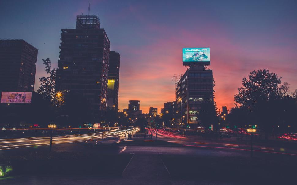 Free Image of Cityscape at sunset with vibrant lights and tall buildings. 