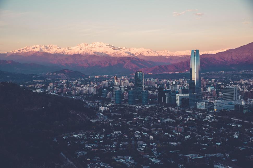 Free Image of City skyline with mountains in the background at dawn. 