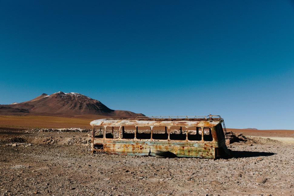 Free Image of Abandoned bus rusting in desolate desert landscape 