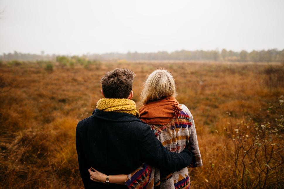 Free Image of Couple embracing with fall landscape background 