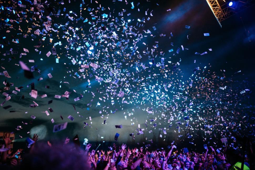 Free Image of Concert crowd enjoying confetti shower at night show 