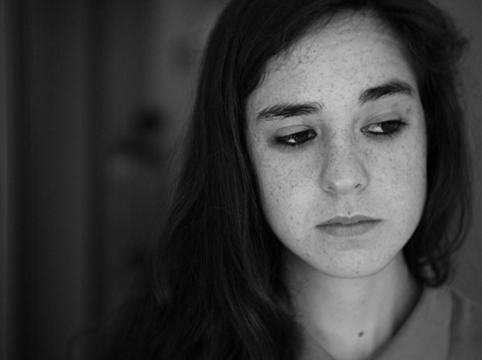 Free Image of Freckled woman looking away in black and white portrait. 