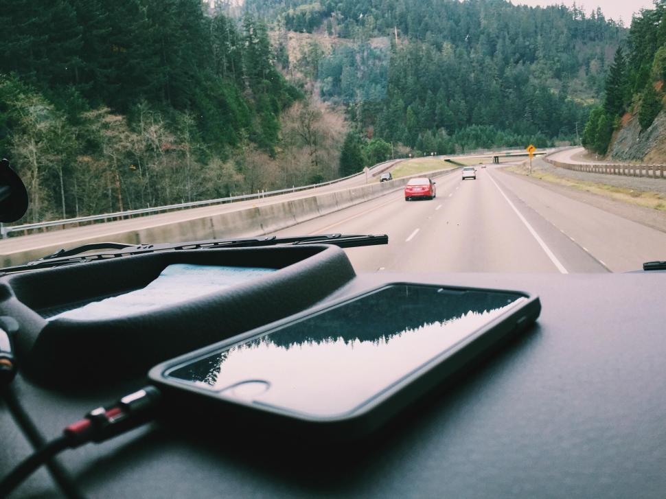 Free Image of Highway drive with smartphone on car dashboard, scenic view 