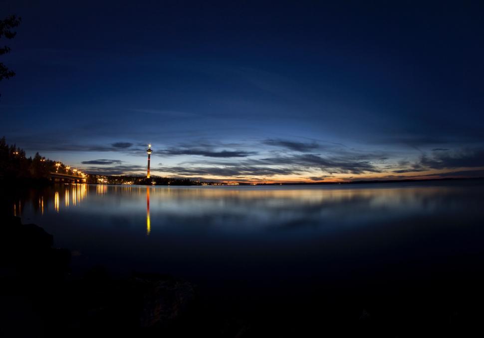 Free Image of Beautiful lighthouse on a serene lake at twilight. 