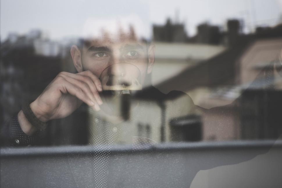 Free Image of Blurry reflection of person in glass pane, urban setting. 