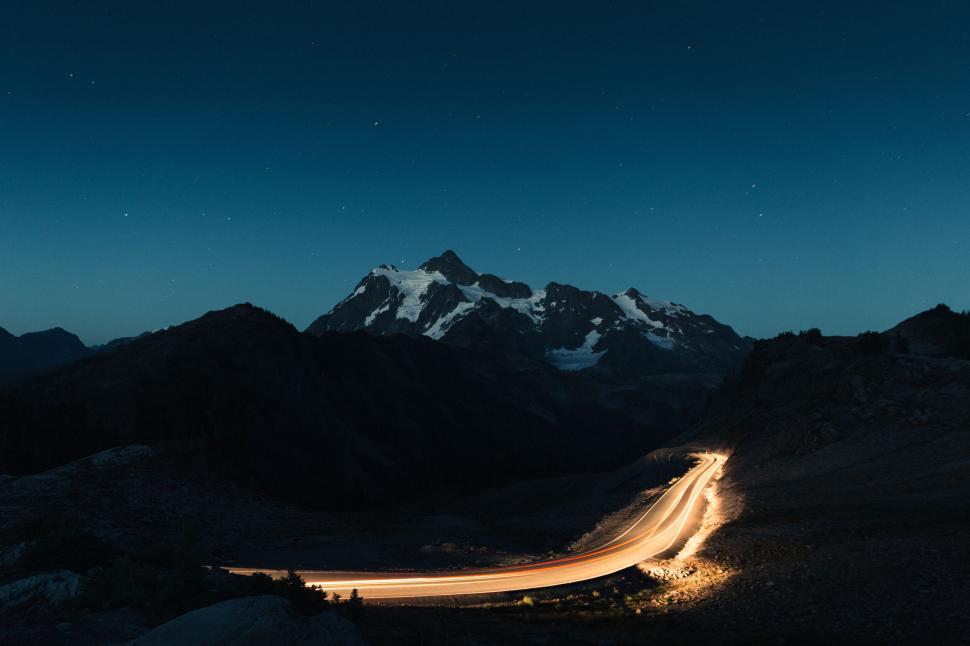 Free Image of Long exposure photograph of a mountain road at night. 