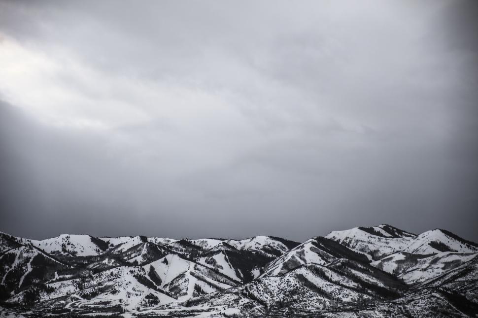 Free Image of Snow-covered mountain ridge under overcast sky 