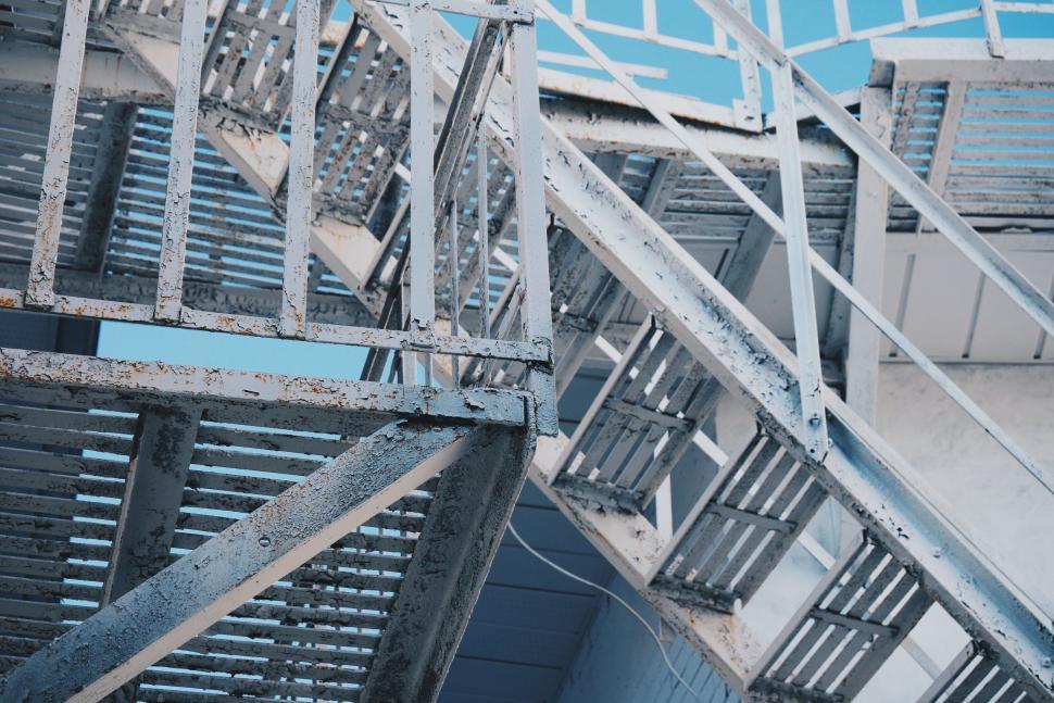 Free Image of Complex white metal fire escape stairs against blue sky. 