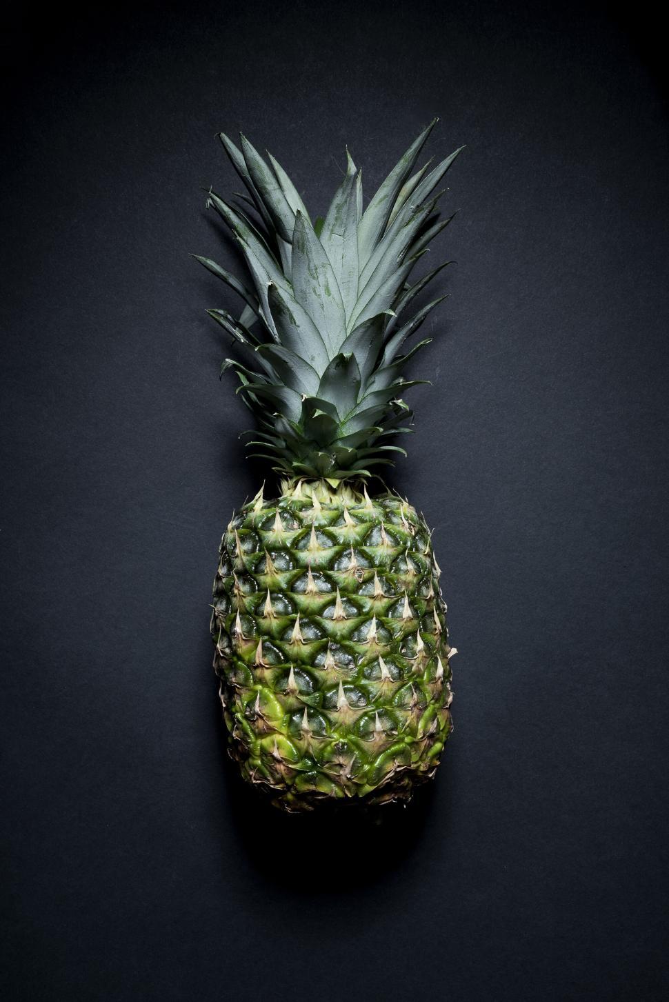 Free Image of A whole pineapple against a black background, top view. 