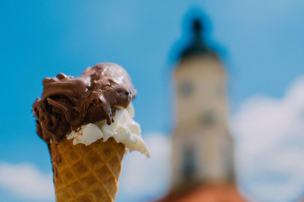 Free Image of Ice cream cone with chocolate and vanilla on blue sky. 
