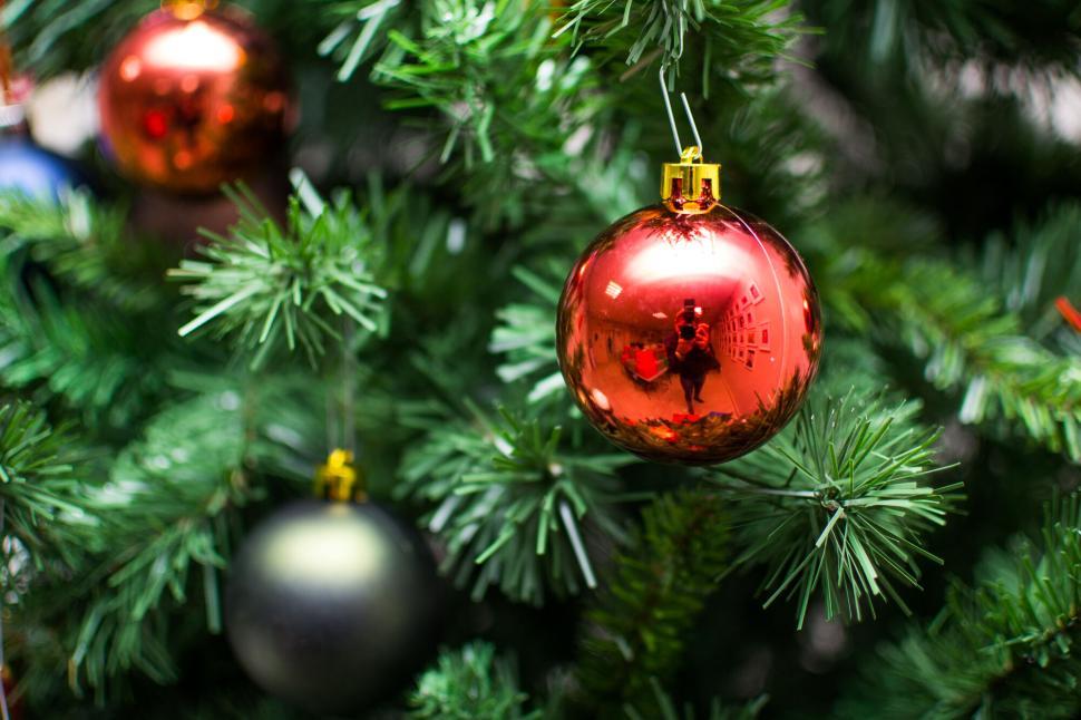 Free Image of Christmas tree with bright, reflective ornaments hanging. 