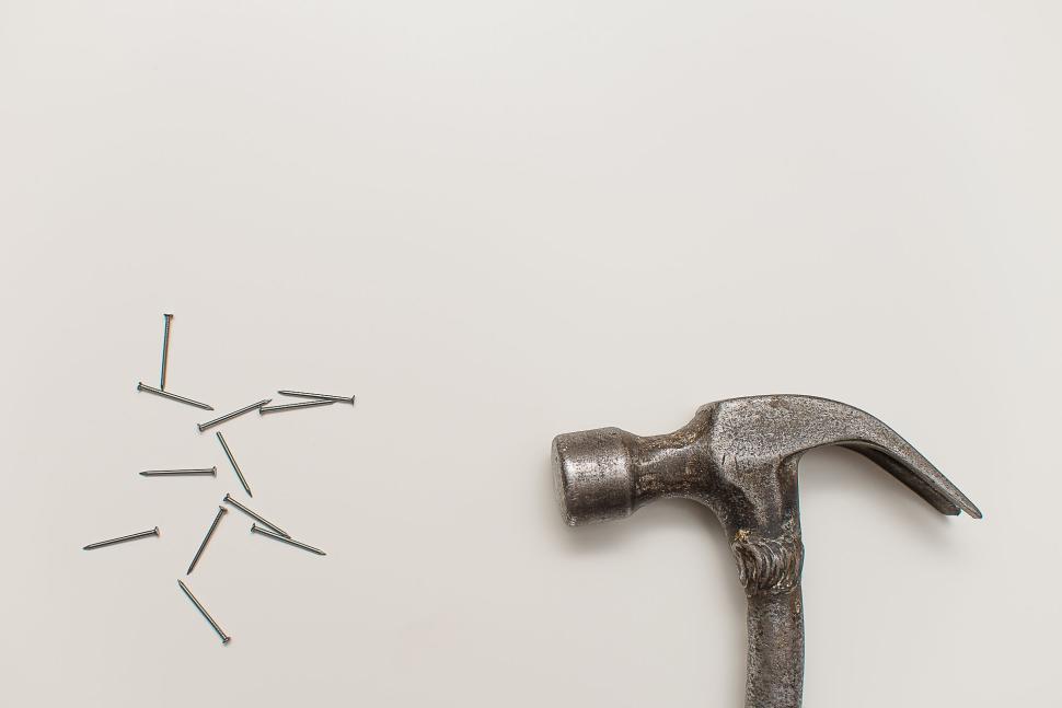 Free Image of Vintage hammer with nails on a white surface flat lay 