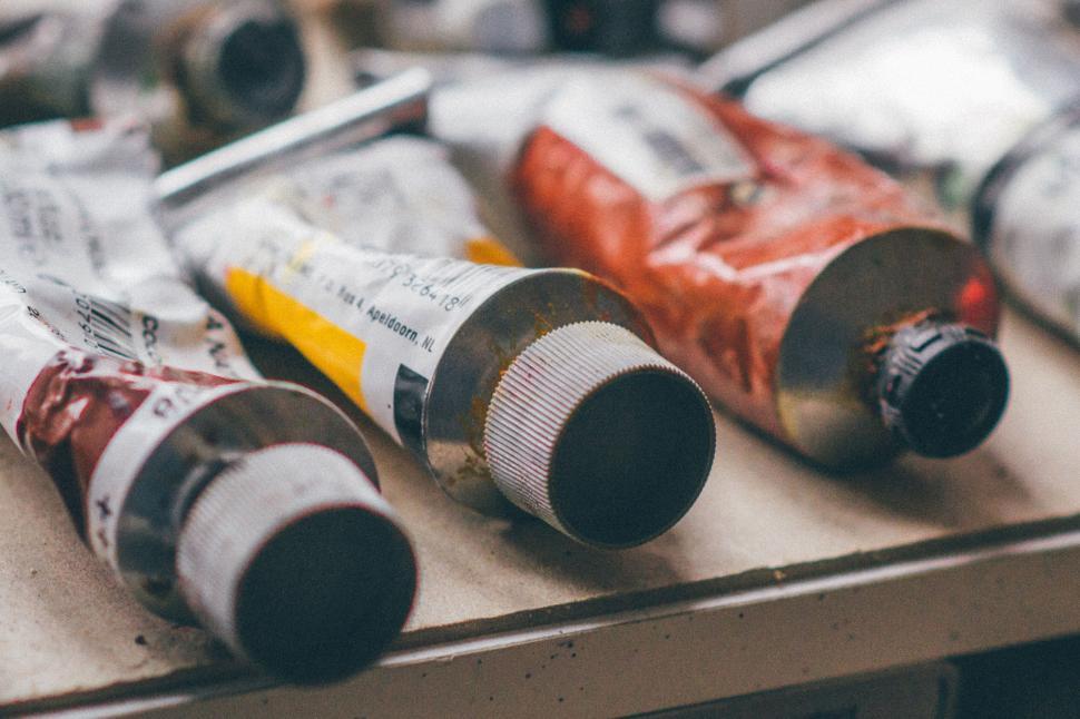 Free Image of Assorted tubes of paint arranged on a table surface 