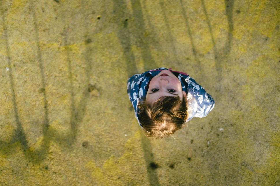 Free Image of Person in a dinosaur jacket walking on a textured surface. 