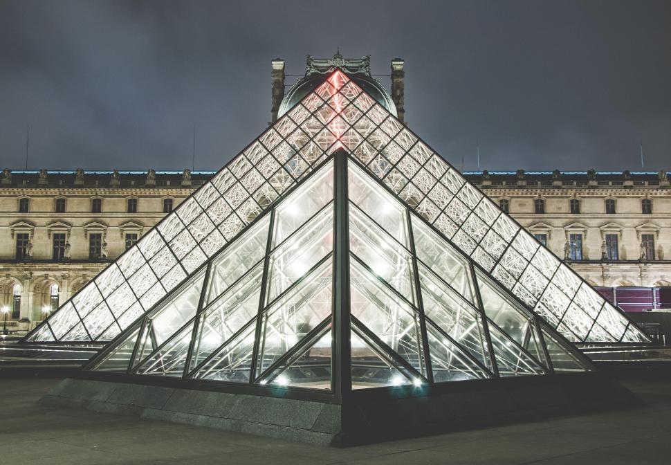 Free Image of Glass pyramid in front of Louvre Museum under cloudy sky 