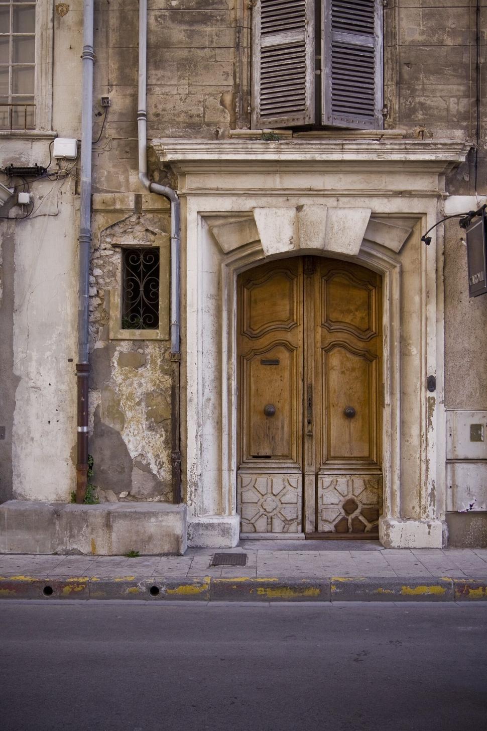 Free Image of Old wooden door in weathered stone building with detail 
