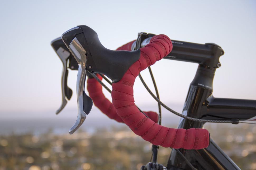 Free Image of Close-up of racing bike handlebars with red tape grips 