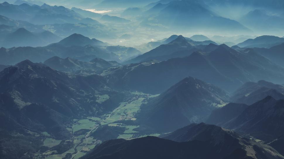 Free Image of Misty mountain range during day with green valleys below. 