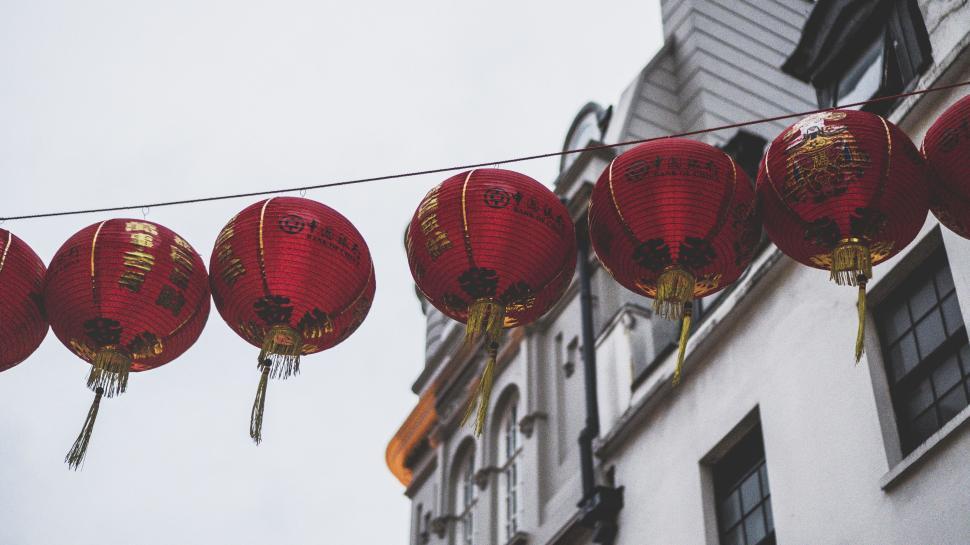 Free Image of Red lanterns string across traditional buildings at night. 