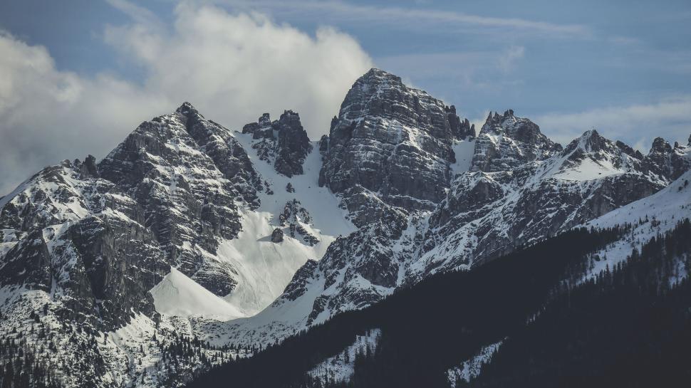 Free Image of Snow-covered mountain peaks under a bright blue sky. 