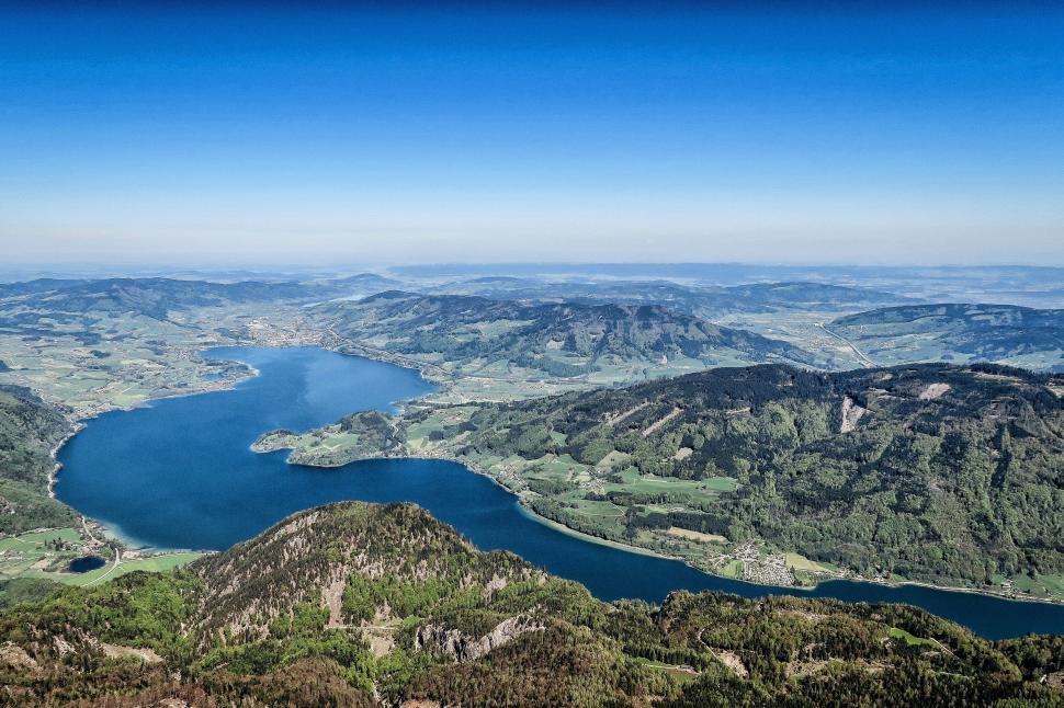 Free Image of Aerial view of lake and green landscape under blue sky 
