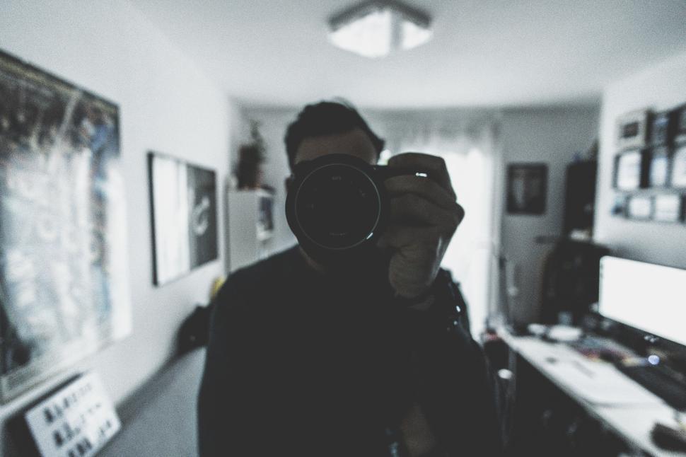 Free Image of Person taking photo inside a room with blurred face visible 