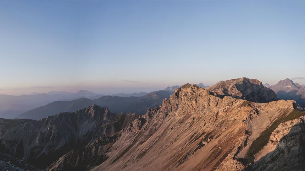 Free Image of Rocky mountain landscape bathed in golden sunlight 