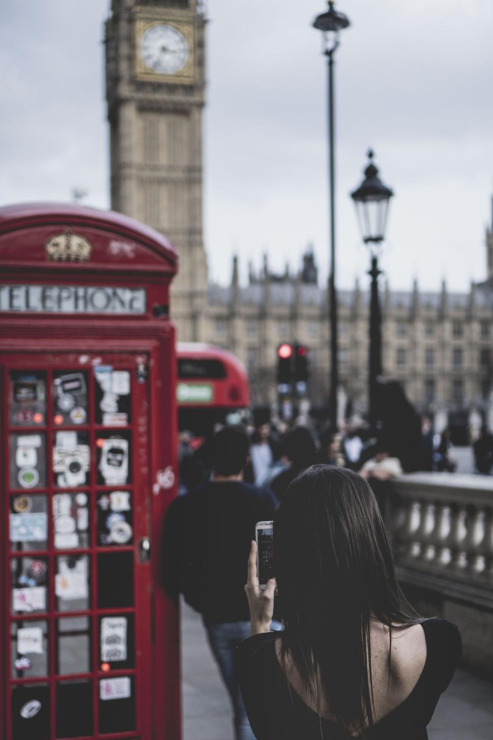 Free Image of Tourist capturing sights near iconic telephone booth 