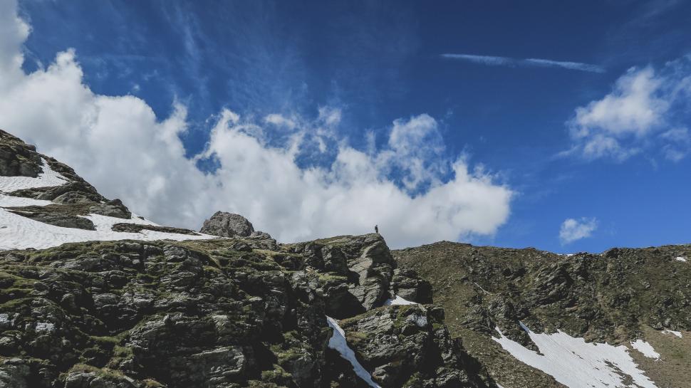 Free Image of Person standing on snowy mountain under blue sky 