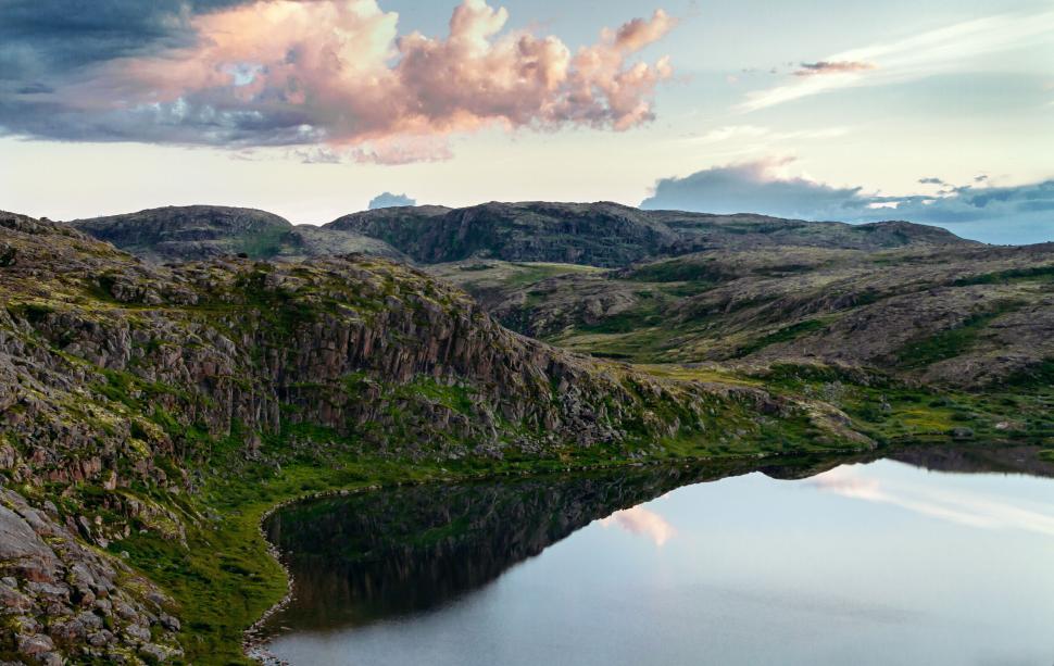 Free Image of Serene lake surrounded by rocky hills during twilight 