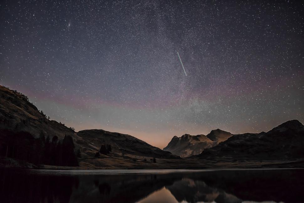 Free Image of Night Sky with Star Trail Over Serene Mountain Lake 