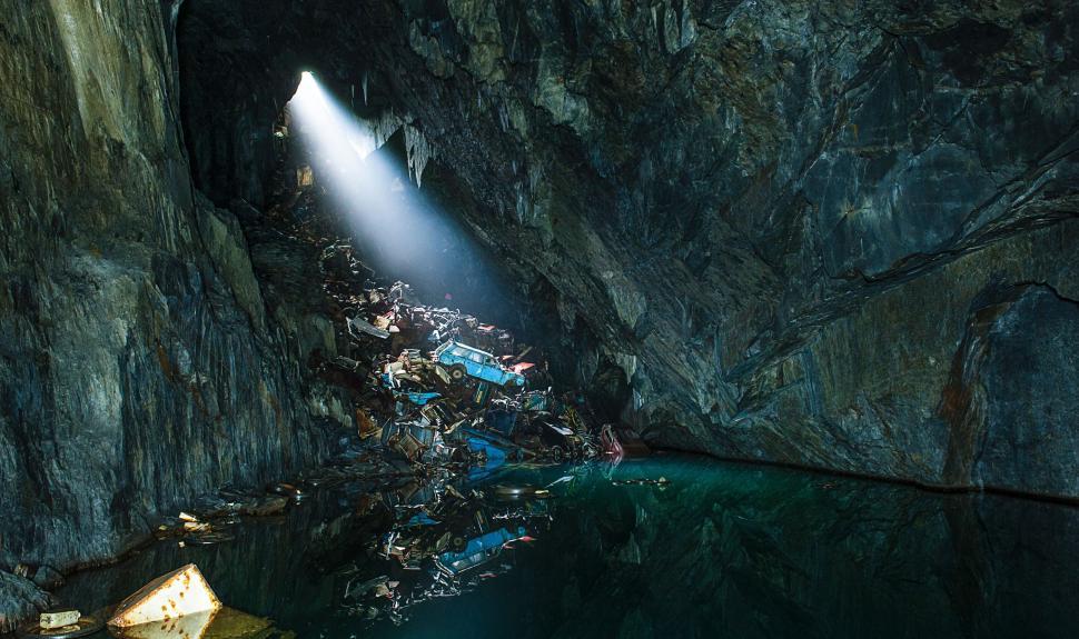 Free Image of Light shining through cave onto pile of debris below. 